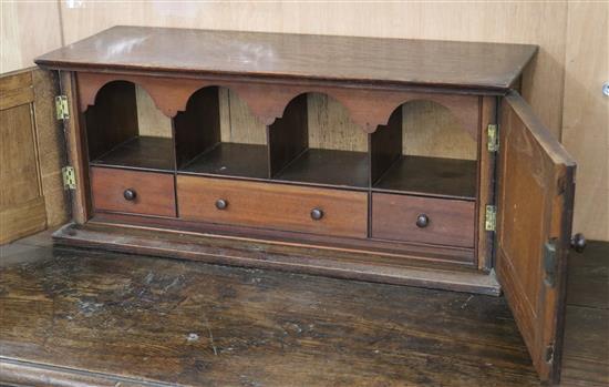 An oak two door cabinet, containing pigeon holes W.63cm